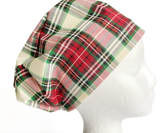 May include: A plaid fabric cap in red, green, and cream colors. The cap is made of a soft material and is designed to fit comfortably. The plaid pattern features a classic tartan design, making it a stylish accessory.