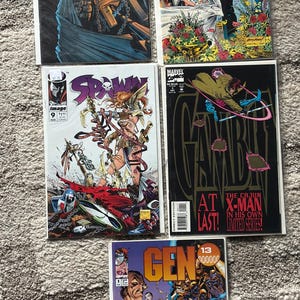 May include: A collection of comic books featuring vibrant illustrations. Titles include "Spawn," "X-Men," and "Gambit." The covers showcase action-packed scenes with characters in dynamic poses, and bold colors. The comic books are from Marvel and Image Comics.