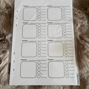 May include: A white planner insert with a grid layout for pattern tracking. Each section includes a space labelled "Pattern:" followed by a box and a series of check boxes. The insert is designed to be inserted into a binder.