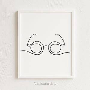 Puede incluir: Lámina artística minimalista enmarcada. La obra presenta un dibujo de línea continua negra de gafas redondas sobre fondo blanco. La impresión está enmarcada en blanco. El nombre del artista, AsmistaArtista, está impreso en la parte inferior.