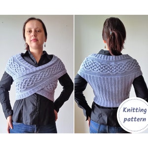 Op de afbeelding: Een lichtblauwe gebreide omslagdoek met een kabelbreipatroon. De omslagdoek wordt gedragen over een zwart shirt en een blauwe jeans. De tekst "Knitting pattern" is zichtbaar in de afbeelding.
