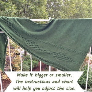 以下が含まれることがあります： ケーブル模様の緑色のニットショール。テキスト「Make it bigger or smaller. The instructions and chart will help you adjust the size.」は白い背景に印刷されています。
