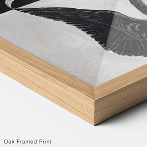 May include: A black and white framed print of a bird with its wings spread wide. The frame is made of natural oak wood.