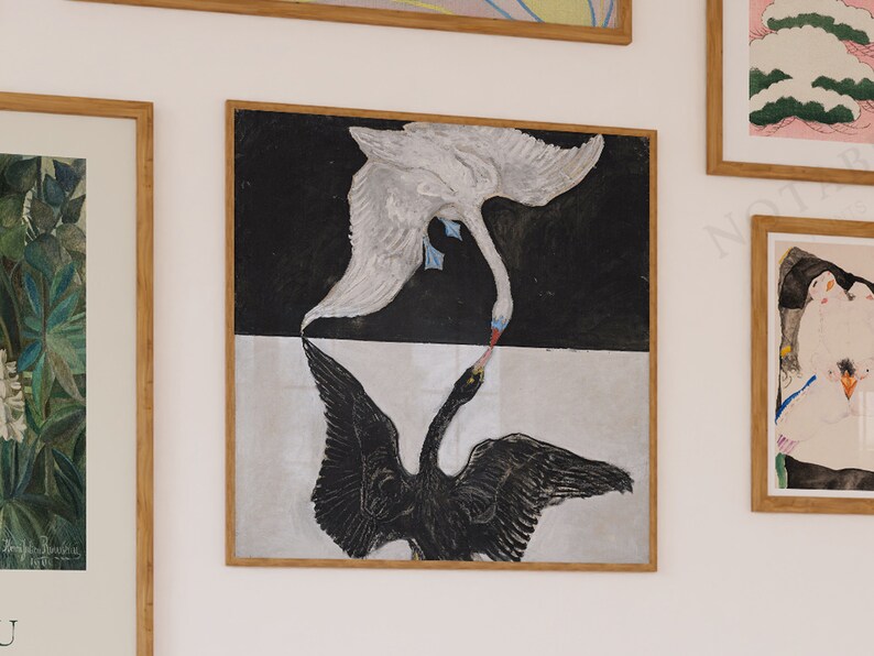 May include: A framed print of a black and white painting depicting two swans with their necks intertwined. The swan on top is white and the swan on the bottom is black. The background is a black and white checkered pattern.