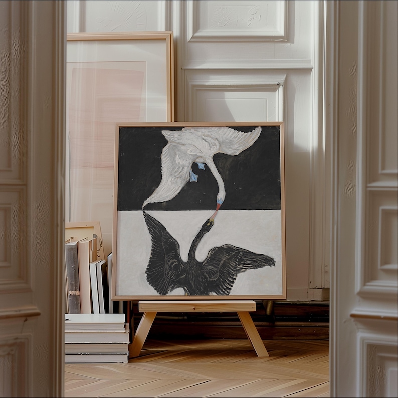 May include: A framed painting of two swans, one white and one black, with their necks intertwined. The swans are depicted against a black and white background.