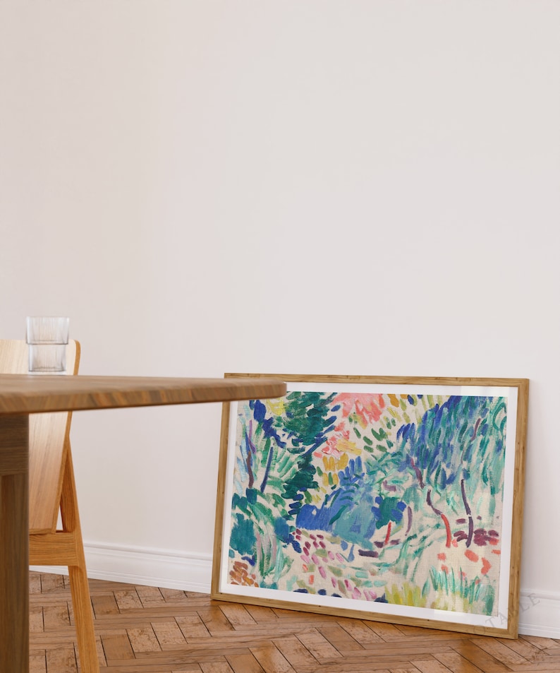 Pode incluir: Uma pintura abstrata enquadrada com uma cena de paisagem colorida. A pintura apresenta uma variedade de tons de azul, verde, rosa e amarelo. A pintura &eacute; enquadrada em uma moldura de madeira natural.