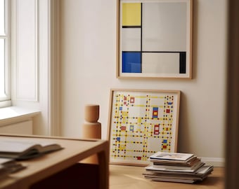 May include: Two framed abstract art prints with geometric designs in yellow, blue, black, and white hang on a light-colored wall. A stack of books and a wooden sculpture sit nearby. The artwork is in wooden frames.