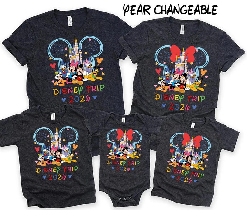 May include: A collection of dark gray t-shirts and a onesie featuring a colorful Disney design. The design includes Mickey Mouse ears, a castle, and various Disney characters. The text "DISNEY TRIP 2026" is displayed in rainbow colors.