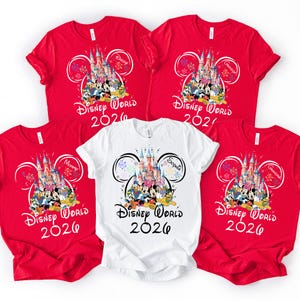 May include: Five t-shirts, four red and one white, featuring a Disney World 2026 design. The design includes a castle, Disney characters, and the text "Disney World 2026". Some shirts have additional text like "Mommy", "Daddy", "Grandma", and "Sophia".