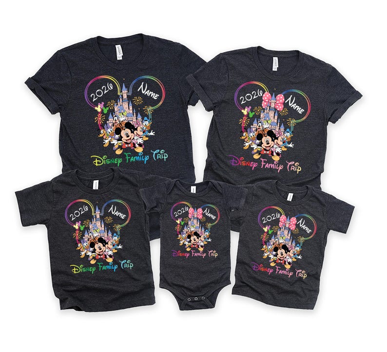 May include: A set of dark grey t-shirts and a onesie with a colourful Disney design. The design includes Mickey Mouse, a castle, and the text "2026", "Name", and "Disney Family Trip". The shirts are short-sleeved.