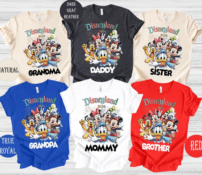 May include: A collection of colorful t-shirts featuring a Disneyland 2026 graphic with various Disney characters. The shirts are in natural, dark gray, blue, white, and red, with text for Grandma, Daddy, Sister, Grandpa, Mommy, and Brother.