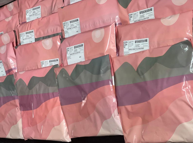 a collection of pink and gray packages or bags arranged in rows, with some of them labeled with shipping labels.