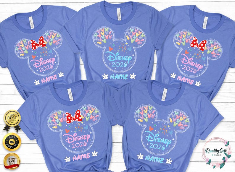 A collection of five blue t-shirts with Disney-themed designs, including Mickey Mouse ears and colorful balloons. The shirts have the text "Disney 2020" and "NAME" printed on them, suggesting they are personalized t-shirts for Disney guests.