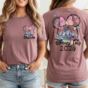 May include: Mauve t-shirt featuring a Minnie Mouse bow design with a castle and the text "Disney Trip 2020" on the back. The front of the shirt has a smaller Minnie Mouse bow design and the word "Grandma".