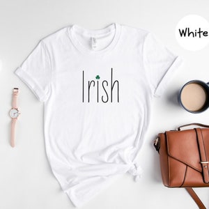 May include: White t-shirt with the word "Irish" printed in black with a small green shamrock above the "i".