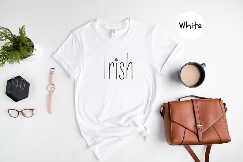 May include: White t-shirt with the word "Irish" printed in black with a small green shamrock above the "i".