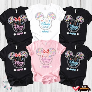 a collection of Disney-themed t-shirts, each featuring a unique design of Mickey Mouse ears and the text "Disney 2020" printed on them. The t-shirts are arranged in a grid pattern, showcasing various colors and styles.
