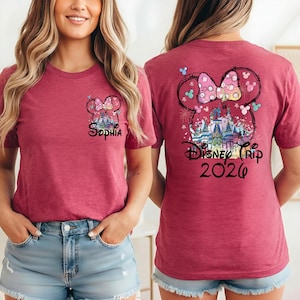 May include: A maroon t-shirt featuring a Minnie Mouse design with the text "Sophia" on the front. The back of the shirt displays a larger Minnie Mouse design with a castle and the text "Disney Trip 2026".