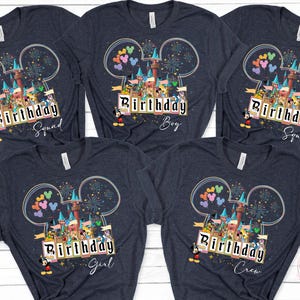 May include: Dark gray t-shirts with a colorful graphic featuring a castle, Mickey Mouse, and the text "Birthday Squad", "Birthday Boy", "Birthday Girl", and "Birthday Crew". The design includes fireworks and balloons.