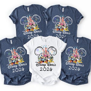 May include: Five t-shirts with a Disney World 2026 design. Four are navy blue, and one is white. The design features a castle, Disney characters, and the text "Disney World 2026". Some shirts have family member names.
