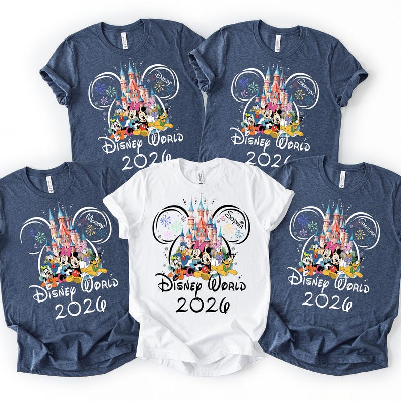 May include: Five t-shirts with a Disney World 2026 design. Four are navy blue, and one is white. The design features a castle, Disney characters, and the text "Disney World 2026". Some shirts have family member names.