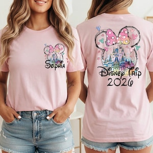 May include: Pink t-shirt featuring a Minnie Mouse design with the name "Sophia" on the front. The back of the shirt displays a Disney castle graphic with the text "Disney Trip 2026". The design includes a bow and fireworks.