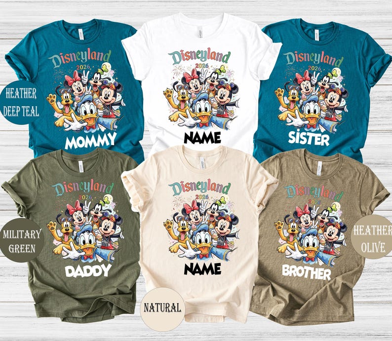 May include: A collection of colorful Disneyland 2026 graphic t-shirts in various colors, including teal, white, olive, and natural. Each shirt features a Disney character design and text such as "Mommy," "Sister," "Daddy," "Brother," and "Name."