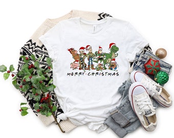 May include: White t-shirt with a graphic of the Toy Story characters wearing Santa hats and the text "Merry Christmas".