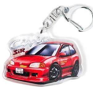 Puede incluir: Un llavero de acrílico transparente con un Honda Civic SiR EG6 rojo y un anillo de llave plateado. El llavero está ilustrado de forma caricaturesca con el texto "Civic SiR EG6" y "Special Tuning" en el lateral.