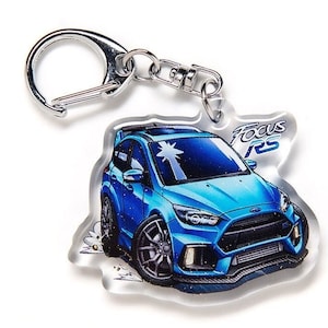 Peut inclure: Un porte-clés Ford Focus RS bleu avec un anneau de clé argenté. Le porte-clés est en acrylique transparent et présente une illustration de la voiture en dessin animé.