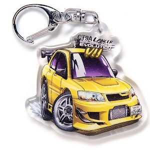 Może przedstawiać: Brelok do kluczy w kolorze żółtym z Mitsubishi Lancer Evolution VII i srebrnym kółkiem. Brelok przedstawia kreskówkową ilustrację samochodu z napisem "CT9A Lancer Evolution VII" na górze.
