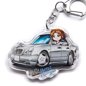 Puede incluir: Un llavero de acrílico transparente con un Mercedes-Benz Clase E W210 plateado y una chica de anime de dibujos animados conduciendo el coche. El llavero tiene el texto "PAPA Benz" y "E-Class W210" impreso.