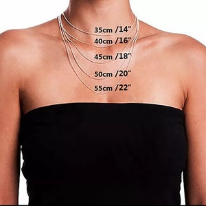 May include: A model wears a silver chain necklace in five different lengths, with measurements in inches and centimetres labelled on the image. The lengths are 14 inches (35 cm), 16 inches (40 cm), 18 inches (45 cm), 20 inches (50 cm), and 22 inches (55 cm).