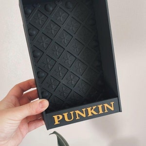 May include: Black plastic storage box with a textured bottom and the word "PUNKIN" printed in gold letters on the front.