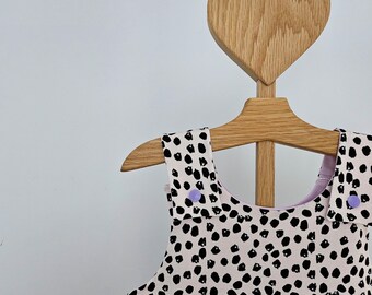 Beige and Black Spotted Baby Dungarees. Fully double lined with lilac to create complimentary turn up cuffs and lilac popper shoulders.