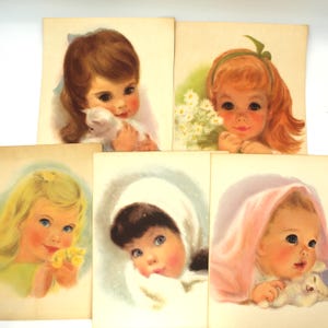 May include: A collection of vintage greeting cards featuring illustrations of children. The cards depict girls with various hairstyles, holding flowers, kittens, and wrapped in blankets. The color palette includes soft pastels and warm tones.
