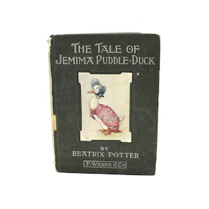 May include: A vintage hardcover book titled "The Tale of Jemima Puddle-Duck" by Beatrix Potter. The cover features a green background with a picture of a duck wearing a pink dress and a blue bonnet.