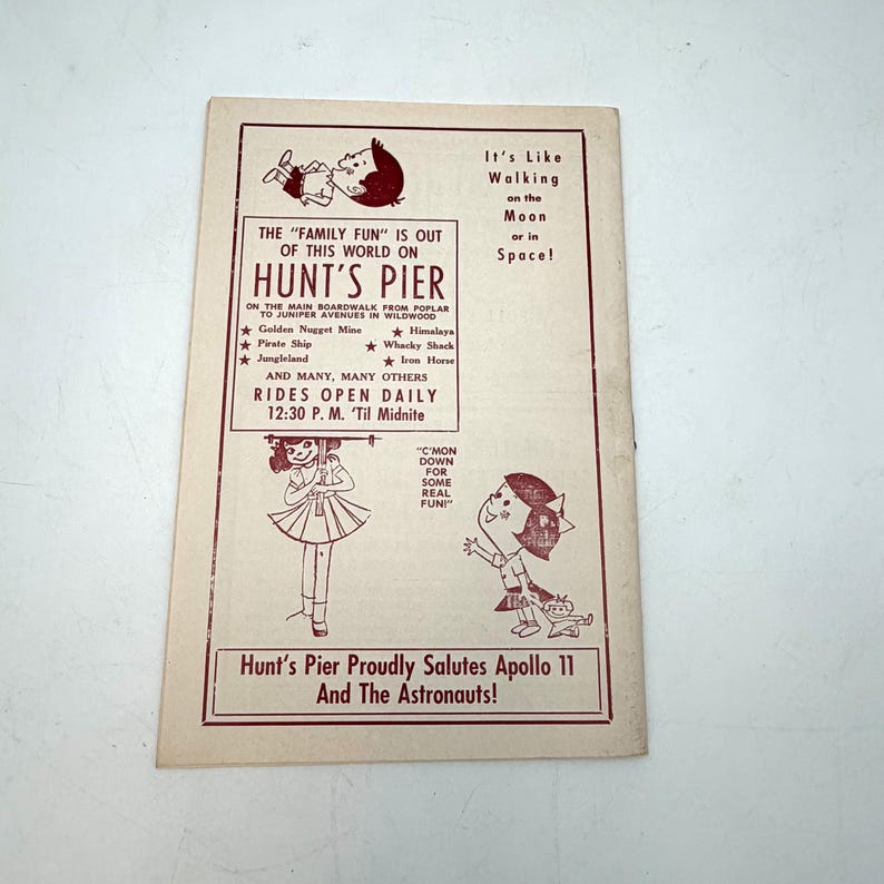 May include: Vintage Hunt's Pier advertisement with maroon text and illustrations. The text promotes rides and attractions, including Jungleland and the Pirate Ship. The ad also salutes Apollo 11 and the astronauts. The background is off-white.
