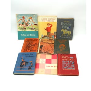 May include: A collection of vintage children's books with colorful covers. Titles include "Working and Playing," "More Roads to Follow," and "The New Friendly Village." The books feature illustrations of children, animals, and scenes from everyday life.