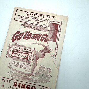 May include: A vintage Wildwood Entertainment Guide from 1969, featuring a surfer illustration and the text "Get Up and Go." The guide promotes the Wildwood Regatta and lists the Hollywood Shoppe with store hours.