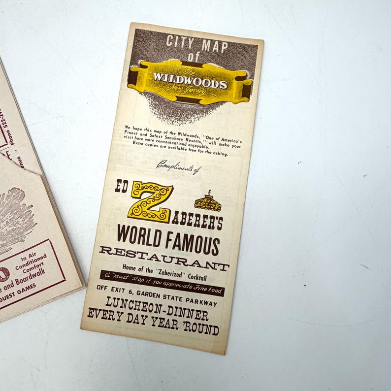 May include: Vintage city map of Wildwoods, New Jersey, with a gold and brown color scheme. The map features the text "City Map of Wildwoods" and "Ed Zaberer's World Famous Restaurant". The map is a vintage travel souvenir.