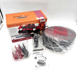 May include: A Remington Protect & Shine hair roller set including an orange and white box, a black heating unit wrapped in plastic, a bag of assorted red and black clips, and a printed use and care guide. The box displays 20 rollers.