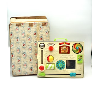 May include: A vintage Fisher-Price 60 Activity Center toy with a white base and colorful features, including a spinning wheel, a mirror, a phone dial, and a sliding bead bar. The toy is in its original box.