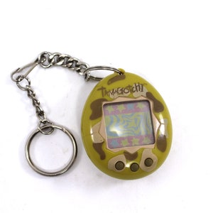Vintage 1990s TamaGotchi - Bandai, 1996, 1997, toy, gigapet, pet, green and beige camouflage, original, instructions