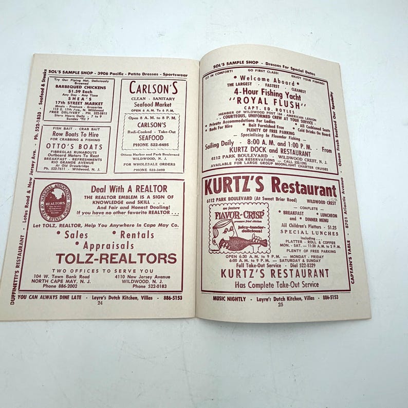 May include: Open magazine pages featuring advertisements for restaurants, seafood, and real estate services. The pages display text and illustrations in a vintage style, with a focus on local businesses and services.