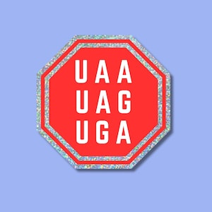 May include: A red, octagonal sticker with a silver glitter border. The sticker features the white text "UAA, UAG, UGA" in three lines, resembling a stop sign. The background is a light blue colour.
