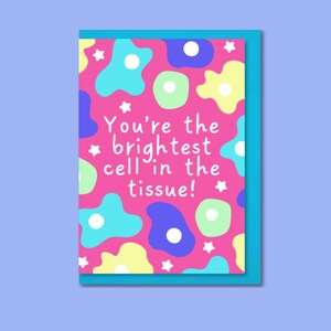May include: A greeting card with a pink background featuring colourful abstract shapes and white stars. The card has the text "You're the brightest cell in the tissue!" in white. The card is set against a blue background.