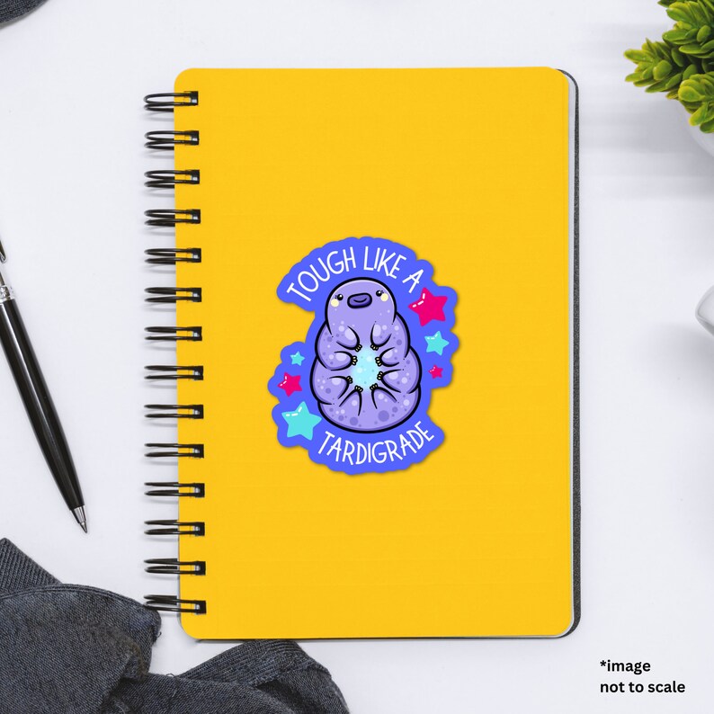 May include: A yellow notebook with a sticker of a purple tardigrade with the text "Tough Like A Tardigrade" and stars.