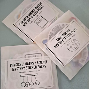 May include: Three translucent paper envelopes containing mystery sticker packs. Labels read Biology & Science (Mixed) Mystery Sticker Packs, Microbiology Mystery Sticker Packs, and Physics / Maths / Science Mystery Sticker Packs with line art icons.
