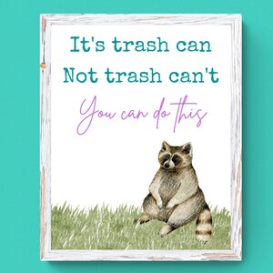 Puede incluir: Una impresi&oacute;n enmarcada en blanco con una cita motivacional: "It's trash can. Not trash can't. You can do this." La cita est&aacute; en texto negro con un "You can do this" en cursiva p&uacute;rpura. Un mapache de dibujos animados est&aacute; sentado en la hierba verde en la parte inferior de la impresi&oacute;n.